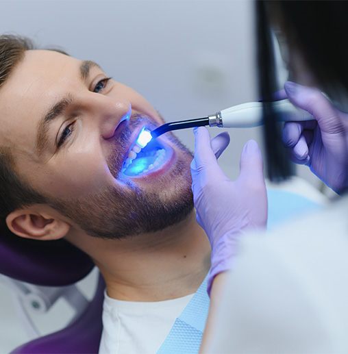 A man receiving tooth-colored fillings from his dentist