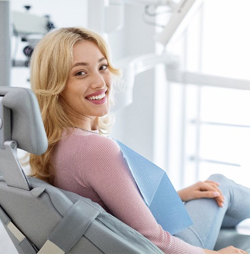 A smiling and relaxed young woman sitting in a dental chair