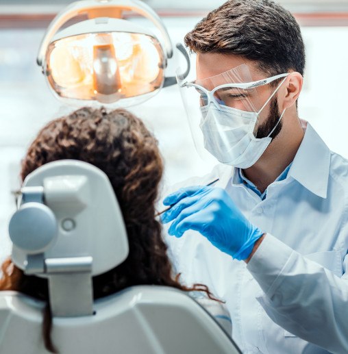 Dentist with blue gloves working on patient