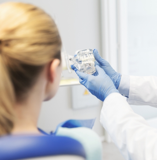 Dentist showing a patient a model of the mouth