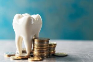 Tooth model sitting next to a stack of coins