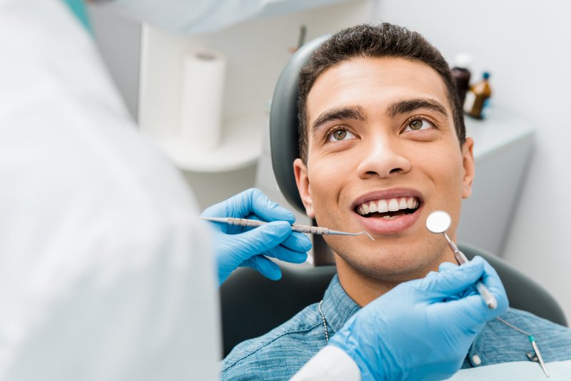 A cheerful young man undergoing a dental checkup