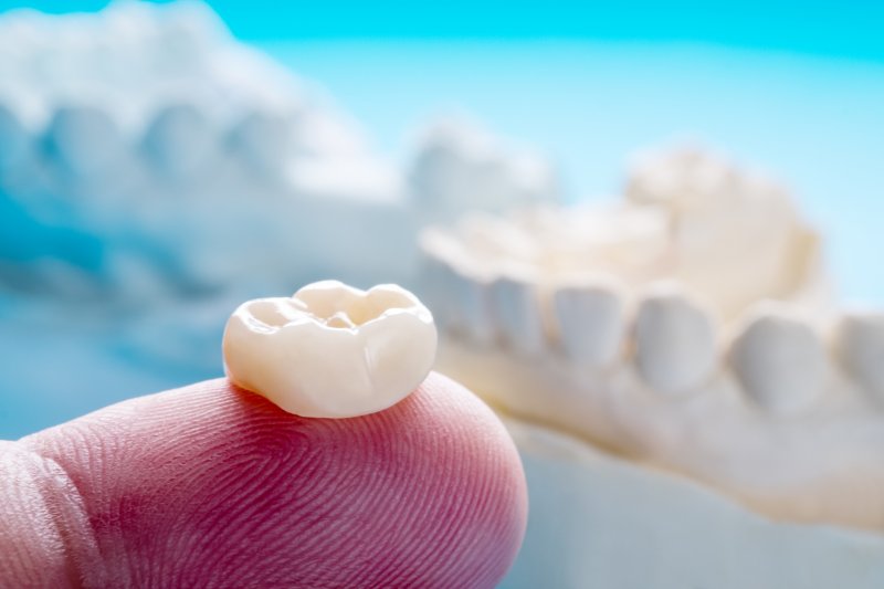 A closeup of a dental crown on a person’s finger